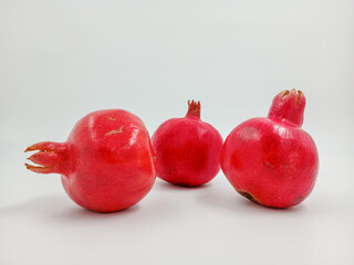 A ruby garnet. Juicy fruit for a vitamin cocktail. A whole red product. Can be used for culinary theme, postcard, supermarket. An isolated object on a white background.