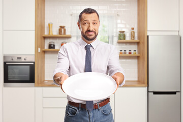 Hungry man holding an empty plate