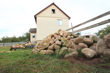 a large pile of different stones against the backdrop of a house