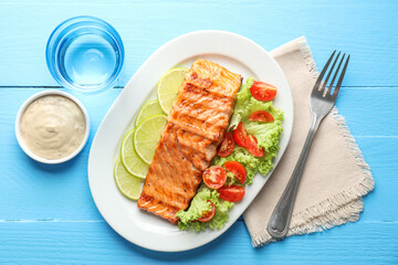 Delicious grilled salmon fillet served on light blue wooden table, flat lay