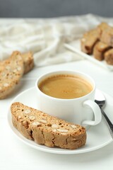 Traditional Italian almond biscuits (Cantucci) and coffee on white table, closeup