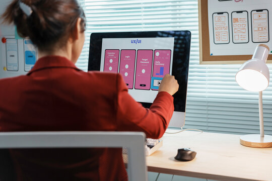 Web designer working on user experience for mobile application using wireframe on computer in office