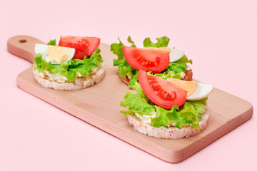 Rice Cake Sandwiches with Tomato, Lettuce and Egg on Wooden Cutting Board. Easy Breakfast. Diet Food. Quick and Healthy Sandwiches. Crispbread with Tasty Filling. Healthy Dietary Snack