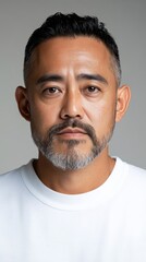 Fototapeta premium 白い T シャツを着た、ひげと短髪の思慮深い男性の肖像画