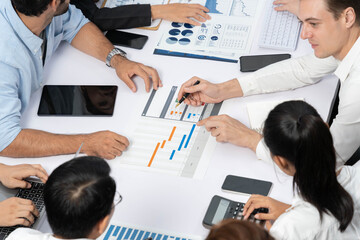 Project manager communicate and collaborate with team using project management software display on monitor, tracking progress of project task and making schedule plan at meeting table. Prudent