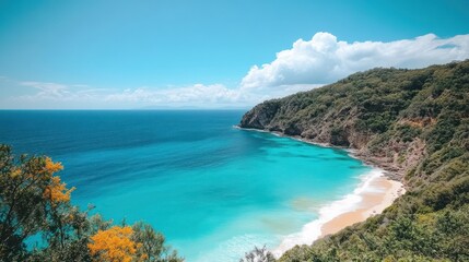 A pristine sandy beach with clear turquoise water and lush green hills in the background.