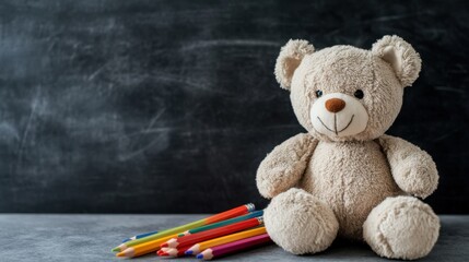 A cheerful teddy bear sits beside a cluster of vibrant, colorful pencils against a chalkboard backdrop, evoking warmth and creativity.