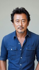 Fototapeta premium ニュートラルな背景にデニムシャツを着た自信に満ちた男性