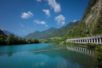 Serene lake stretches out beneath a clear blue sky, reflecting the surrounding mountains