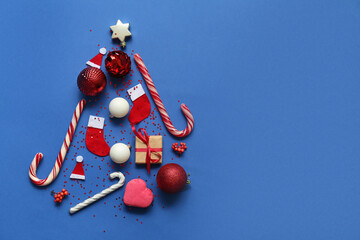 Christmas tree made of balls, candy cane and decor on blue background