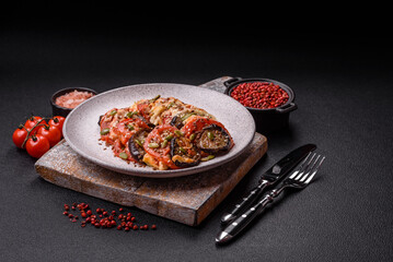 Rings of eggplant, tomato and zucchini with pieces of chicken and garlic