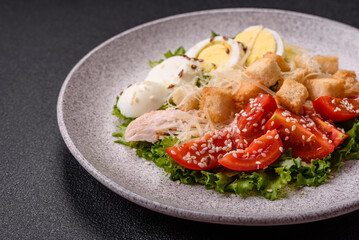 Delicious fresh salad with lettuce, croutons, chicken fillet, tomatoes and egg