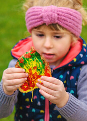 Child drawing autumn leaves. Selective focus.