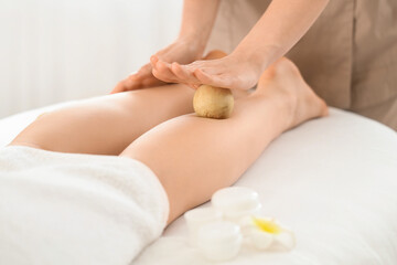 Woman receiving legs massage in spa salon