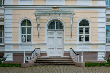 The main entrance with a white wooden door to the manor house. Igate, Latvia.