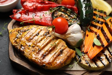 Delicious grilled vegetables and chicken breast on table, closeup