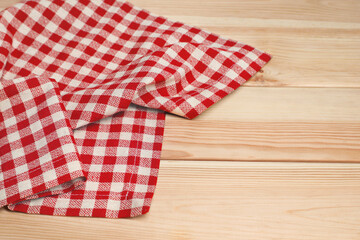Obraz premium Crumpled tablecloth with checkered pattern on light wooden table, space for text