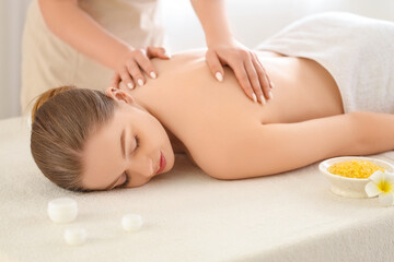 Obraz premium Young woman undergoing massage procedure in spa salon