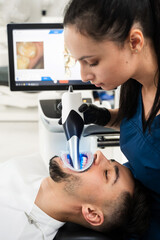 Dentist uses dental scanner to examine teeth of the patient. Digital teeth scanning process.
