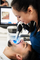 Digital teeth scanning process. Dentist uses dental scanner to examine teeth of the patient.
