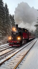 Obraz premium A vibrant red steam locomotive speeds through the snow-covered Black Forest, emitting billowing smoke and surrounded by tall, frosted pine trees beneath a cloud-specked sky