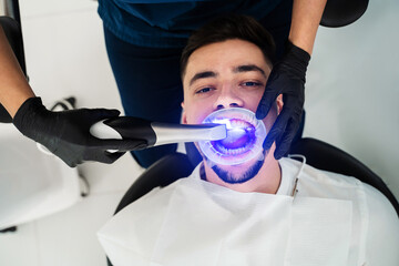 Dentist uses dental scanner to examine teeth of the patient. Digital teeth scanning process.