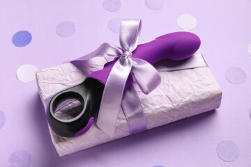 Vaginal sex toy and gift box on lilac background