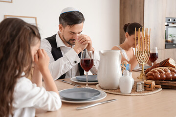 Jewish family praying before dinner at home