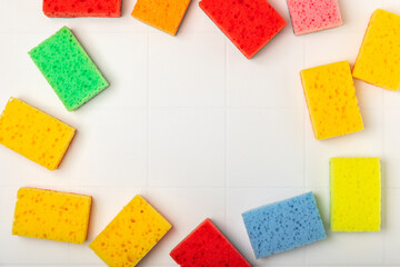 Colorful dish sponges on textured background. Kitchen sponge. Cleaning concept, cleaning service. Dishwashing liquid with clean and dirty dishes plate. Place for text, copy space. Wash the dishes.
