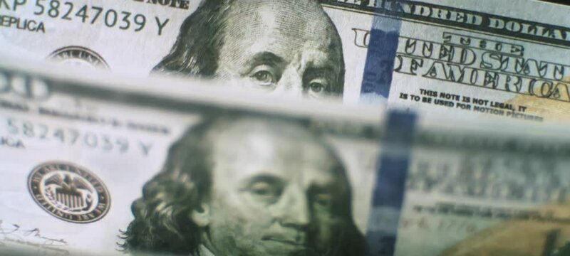 Currency counting machine counting US dollar notes in slow-motion. Currency exchange of one hundred usd