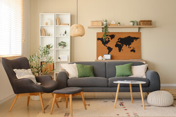 Interior of living room with armchair, sofa and world map on beige wall