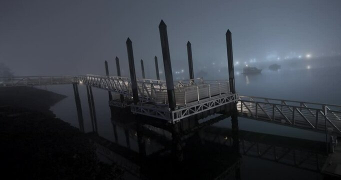 boats in the harbor during a foggy winter night