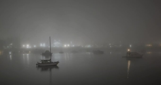 boats in the harbor during a foggy winter night