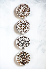 grid of ornate wooden discs on a marble countertop