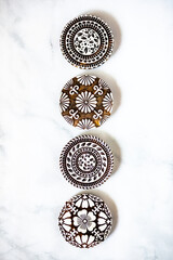 grid of ornate wooden discs on a marble countertop