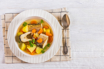 Clear Pike soup with veggies and spices, top view