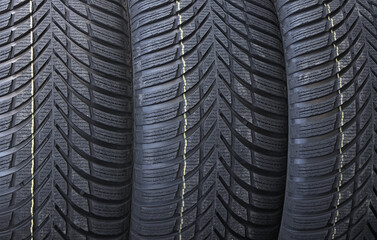 Fototapeta premium Identical Tread Pattern Design Of Non Studded Winter Tyres. New Car Tyres Texture Stock Photo For Background 
