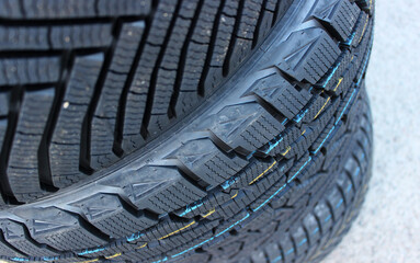 New Winter Tires Stacked On Asphalt Closeup Stock Image. Studless Tires Details