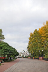 bridge in autumn park, pedestrian path, embankment along the river. Kyiv, Ukraine