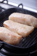 Cod fillets on a skillet.