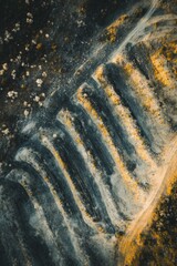 Close-up of textured tire tread pattern on a weathered surface, showcasing dirt and dust accumulation, highlighting wear and grip in outdoor environments.