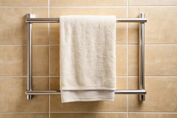 Soft clean white towel hanging on metal rack in modern bathroom with beige tile wall background macro