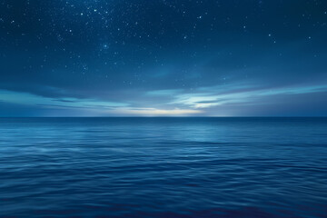 Obraz premium Gentle waves lap at the shore under a vast night sky shimmering with stars. The horizon glows softly as twilight deepens, creating a tranquil atmosphere