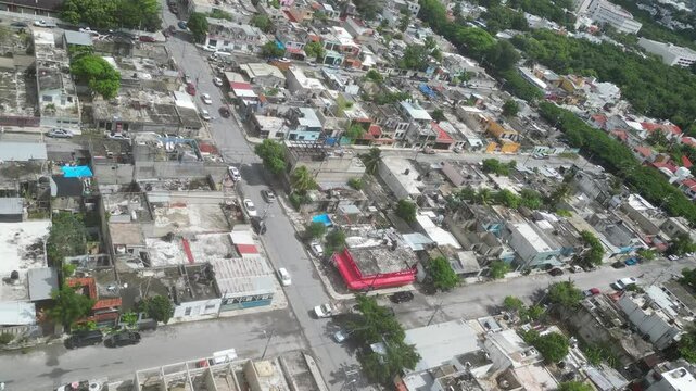 Aerial top-down view high altitude of slum, a heavily populated urban informal settlement characterised by substandard housing and squalor poor living conditions streets and rusty metal home roof tops
