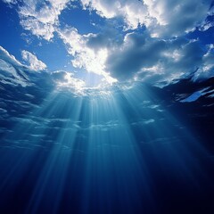 Fototapeta premium Underwater view of sunlight rays penetrating through the surface of the ocean, creating a beautiful and dramatic scene.