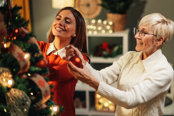 Happy family decorating christmas tree at home