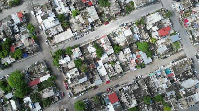 Aerial top-down view high altitude of slum, a heavily populated urban informal settlement characterised by substandard housing and squalor poor living conditions streets and rusty metal home roof tops