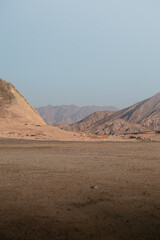 mountain range landscape. The mountains are characterized by sharp rocky outcroppings and steep slopes covered with rocks and little vegetation. The colors of the mountains range from dark brown to li