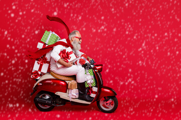 Profile side view of his he nice attractive trendy purposeful gray-haired man riding moto bike delivering pile stack purchase air wind blows isolated on bright vivid shine red background