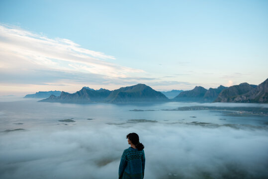 Girl standing above clouds in Lofoten Islands